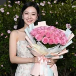 Cô gái châu Á rạng rỡ trong đêm với hoa hồng và nụ cười rạng ngời