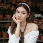 Hình ảnh cô gái xinh đẹp trong cửa hàng hoa với phong cách tự nhiên và trang phục bắt mắt