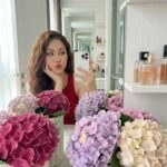 Góc nhìn gần: Cô gái xinh đẹp chụp selfie trong không gian đầy hoa và ánh sáng ấm áp