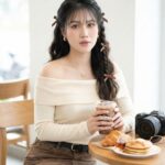 Cô gái duyên dáng trong không gian cà phê với phong cách nhẹ nhàng và thu hút