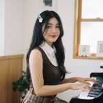 Chân dung cô gái trẻ thanh lịch bên cây đàn piano trong không gian vintage dịu dàng