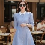 Chân dung cô gái trẻ trong bộ đầm xanh sọc tại quán cà phê sang trọng ngoài trời